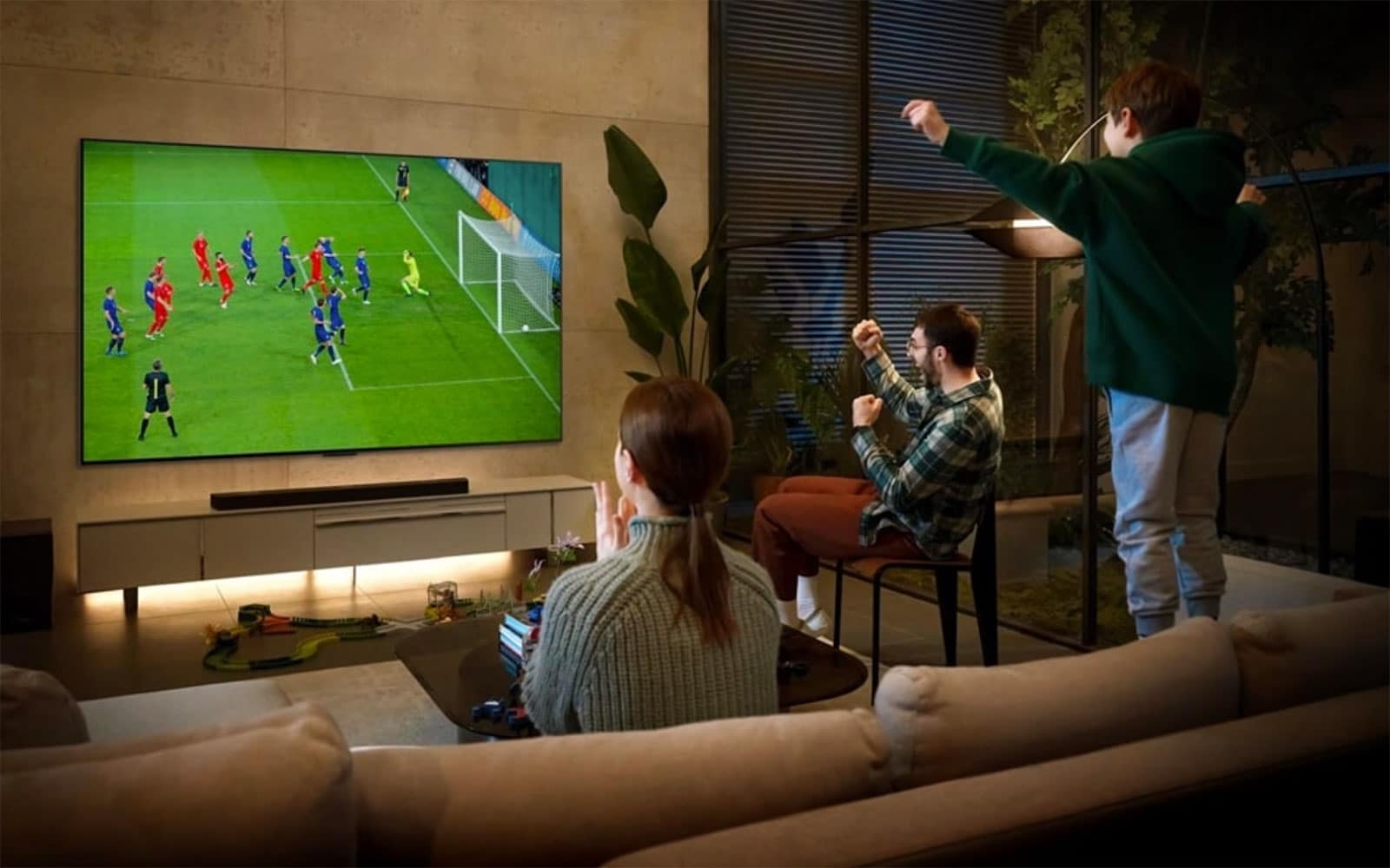 Τηλεόραση μεγάλων ιντσών σε σαλόνι με αγώνα ποδοσφαίρου στην οθόνη